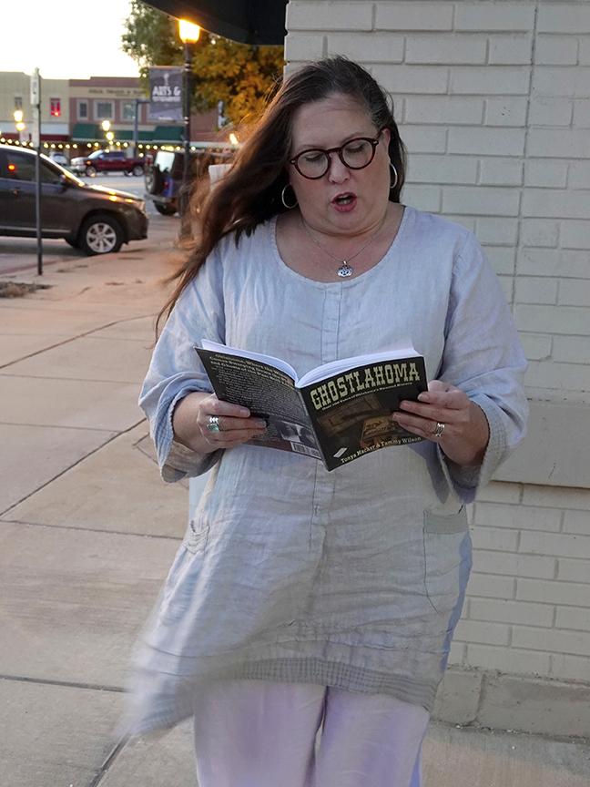 Tammy Wilson reads from the book she co-authored on the corner of Grand and Broadway.