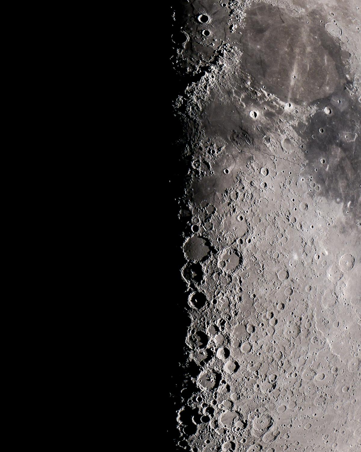 The lunar terminator, or the line splitting night and day, as viewed through an 8”  telescope in Enid, Oklahoma. Photo by Patrick Wine.